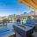 One-BR Apartments In Boise, ID - The Timber at Harris Ranch - Outdoor Firepits With Couch Seating Next To Dining Tables & Chairs, And The Pool With Outdoor Strung Lights