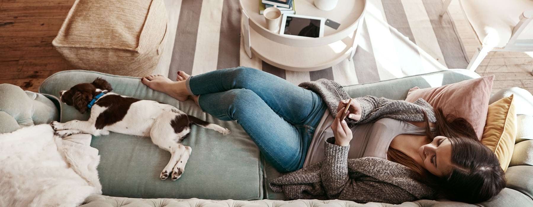 Woman relaxing on a sofa with her dog