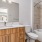 Studio Apartments in Boise, ID - The Timbers at Harris Ranch - Bathroom with Wood-Style Cabinets, Shower with Tub, and Large Mirror. 