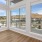 Pet Friendly Apartments in Boise, ID - The Timbers at Harris Ranch - Living Room with Wood-Style Flooring, Large Windows, and Patio Access.